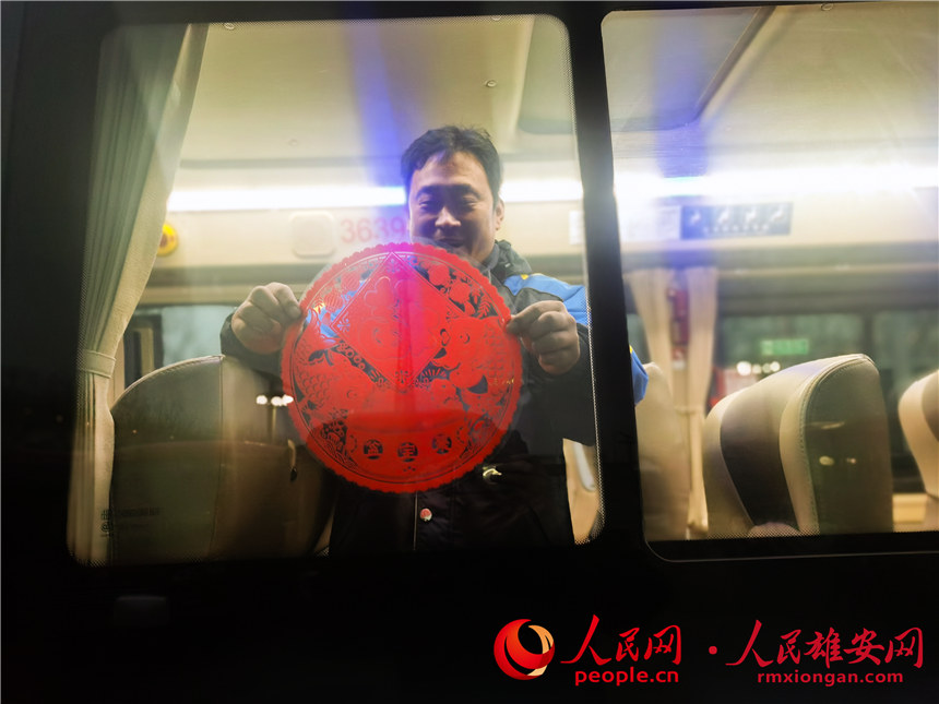圖為雄安公交司機為公交車貼窗花。河北雄安容暢智慧公共交通有限責任公司供圖