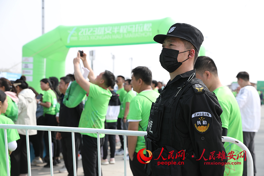 2023雄安半程馬拉松現(xiàn)場，堅(jiān)守崗位的安保人員。人民網(wǎng) 李兆民攝