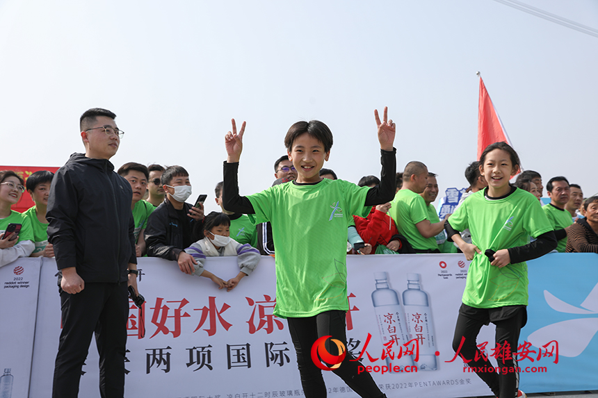 2023雄安半程馬拉松現(xiàn)場(chǎng)，完成健康跑的小選手正在慶祝勝利。人民網(wǎng) 李兆民攝