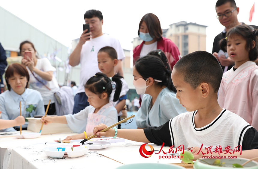 5月31日，雄安容和樂安幼兒園舉辦傳統文化游園活動?；顒友埩诵郯伯數胤沁z文化傳承人走進幼兒園，與孩子和家長交流互動。通過現場接觸非遺項目，讓孩子們零距離認識非遺、熟悉非遺，感受非遺之美。人民網 李兆民攝
