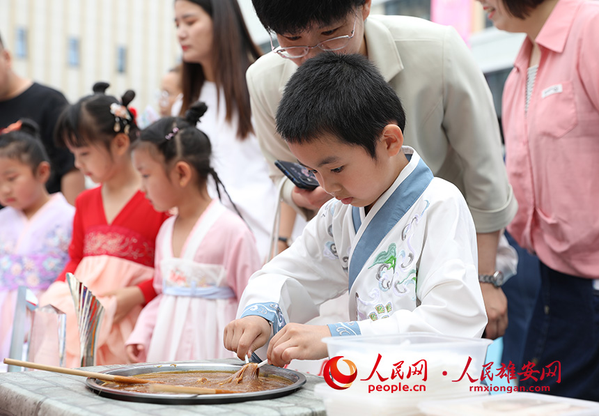 5月31日，雄安容和樂安幼兒園舉辦傳統文化游園活動?；顒友埩诵郯伯數胤沁z文化傳承人走進幼兒園，與孩子和家長交流互動。通過現場接觸非遺項目，讓孩子們零距離認識非遺、熟悉非遺，感受非遺之美。人民網 李兆民攝