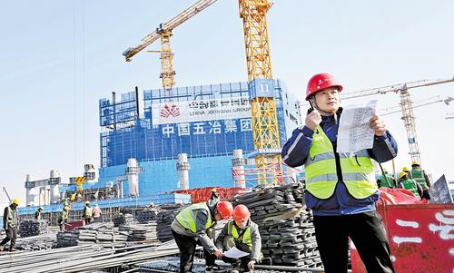 1月20日，雄安城際站及國貿(mào)中心項目建設現(xiàn)場，中國五冶集團雄安國貿(mào)中心項目常務副指揮長黃紹平(右一）正在進行巡查。本報記者 劉光昱攝