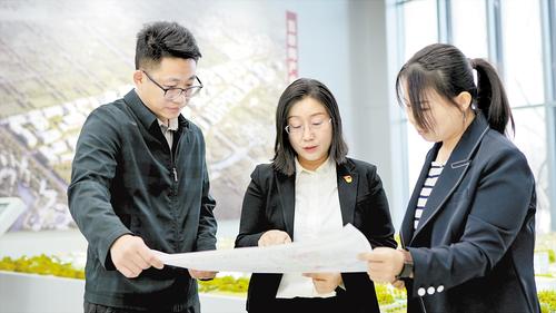 2024年2月，在北京非首都功能疏解中心，夏雨（中）與同事探討項(xiàng)目規(guī)劃。受訪者供圖